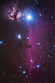 Obszar w okolicy nadolbrzyma Alnitak w Orionie (najjaśniejsza gwiazda na zdjęciu), jest jednym z tych zakątków nieba, gdzie w polu widzenia astrografu można utrwalić interesującą kolekcję mgławic. Ten klasyczny obraz zawiera chyba najsłynniejszą absorpcyjną mgławicę B33 Końska Głowa, przysłaniającą czerwony welon bardziej odległej emisyjnej chmury IC 434. Na lewo od Alnitaka rezyduje NGC 2024 Mgławica Płomień. Obłoki gazu żarzą się tutaj dzięki promieniowaniu gwiazdy skrytej głęboko w jej wnętrzu. Ostatnia bohaterka tej odsłony to mgławica refleksyjna NGC 2023, w której tkwi gorące słońce rozświetlające  błękitne obłoki swym promieniowaniem. Parametry: 2013.12.02-03.23:18-00:51CSE. Reflektor Newtona 205/907+MPCC+N.D300, w ognisku głównym teleskopu. Exp.15x240sek. ISO1600. Doskonałe warunki pogodowe.