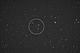 Kometa P/209 Linear. Obraz monochromatyczny, kometa znajduje się w centrum okręgu, strzałką oznaczona jest                 galaktyka PGC 27834, o jasności 15.2mg. Ta krótkookresowa kometa należy do rodziny Jowisza (okres 5,04roku). 29 maja przeleciała                   bardzo blisko Ziemi - w odległości 8 milionów km. W czasie fotografowania dystans do niej wynosił                                         około 15 milionów km. Rozmiary kątowe wskazują, że jest bardzo małym (fizycznie) obiektem. W czasie                                obserwacji jej jasność mogła wynosić 14 - 15mg., a główną trudnością w fotografowaniu był bardzo szybki ruch własny             tej słabej komety. Parametry: 2014.05.19-20. 23:59-00:13CWE. Reflektor Newtona                 205/907+MPCC+NikonD300 w ognisku głównym teleskopu. Exp.2x110sek. ISO1600, 2x110sek. ISO2000. 